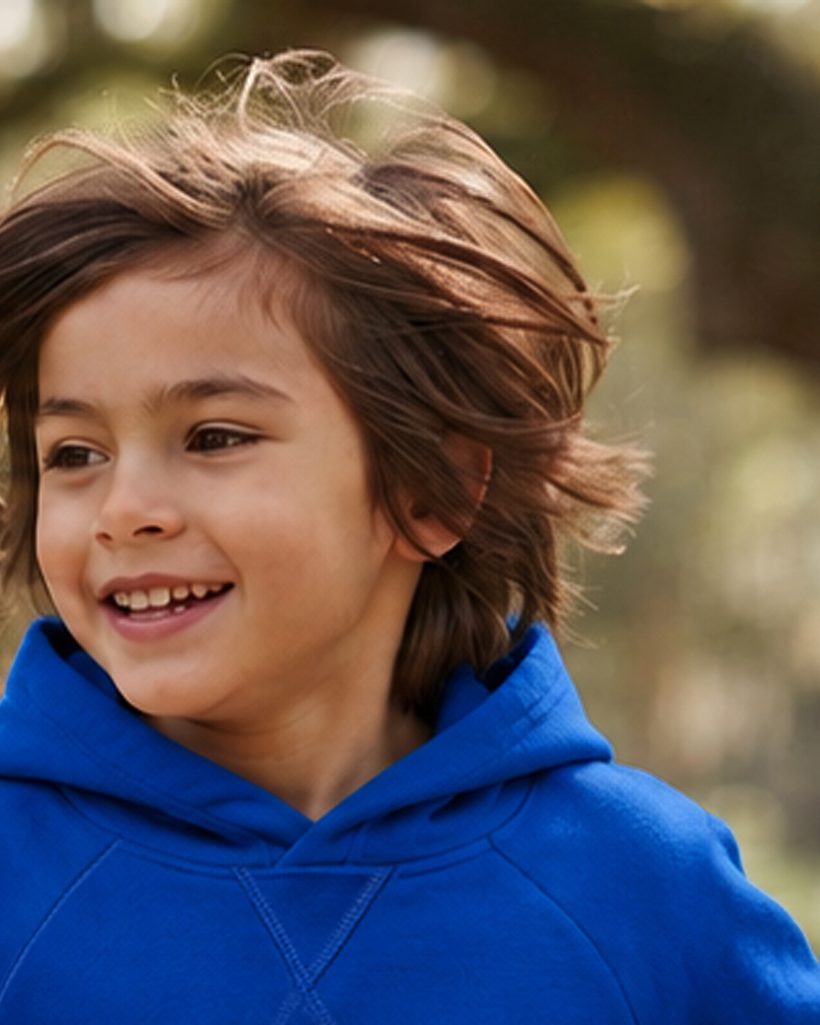 Child smiling in a royal blue pullover hoodie